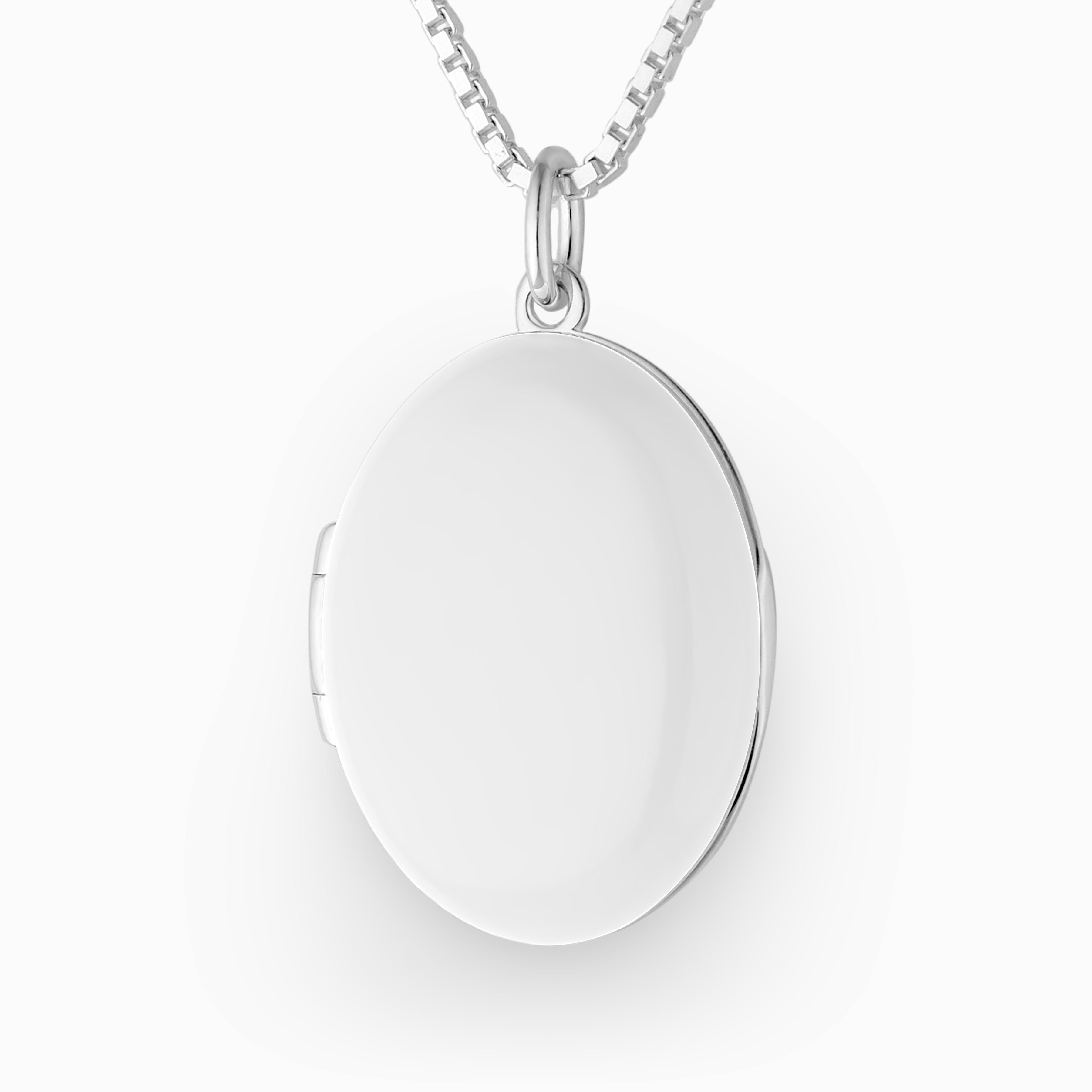 Close up photo of a 925 sterling silver oval locket enamelled in a high gloss white and placed on a box chain.