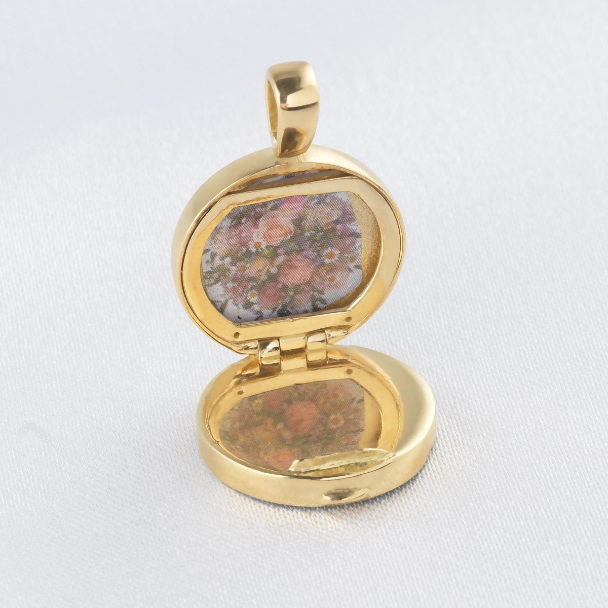 Open view of an 18 ct gold round locket showing an inner glass frame