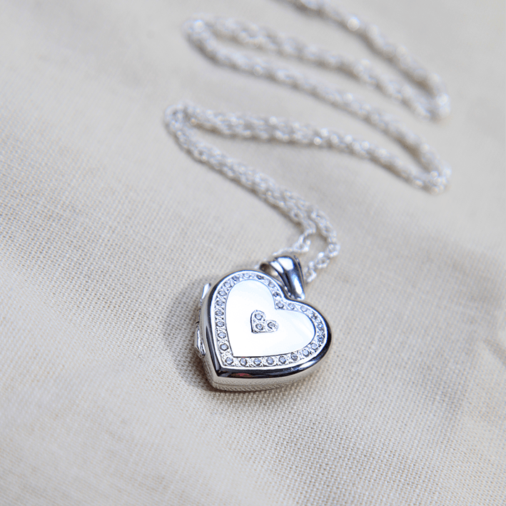 18 ct white gold locket set with a diamond border and 3 diamonds in the centre