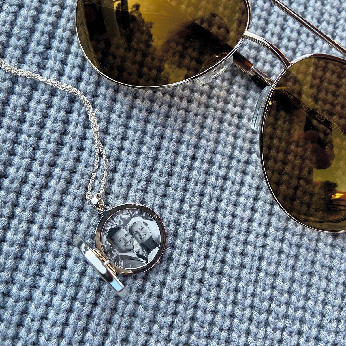 Open view of a round sterling silver locket on a sterling silver rope chain