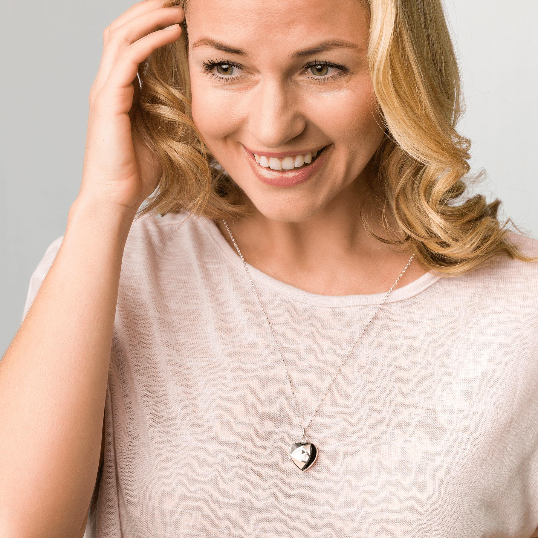 Sterling silver heart shaped locket set with onyx and pink mother of pearl on a sterling silver chain.