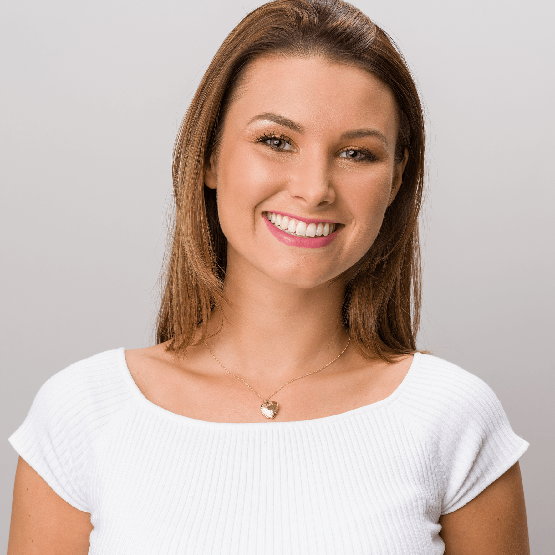 Model wearing a 9 ct gold heart locket embossed with a floral design on a 9 ct gold rope chain