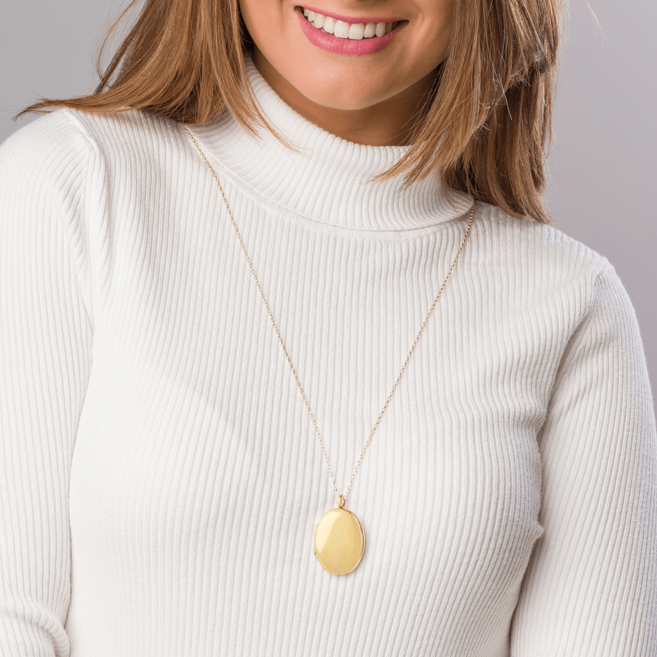 Model wearing a large oval 9 ct gold 4-photo polished locket on a 9 ct gold belcher chain