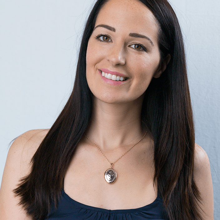 Model wearing a 9 ct gold oval locket embossed with a celtic cross and a celtic border on a 9 ct gold rope chain