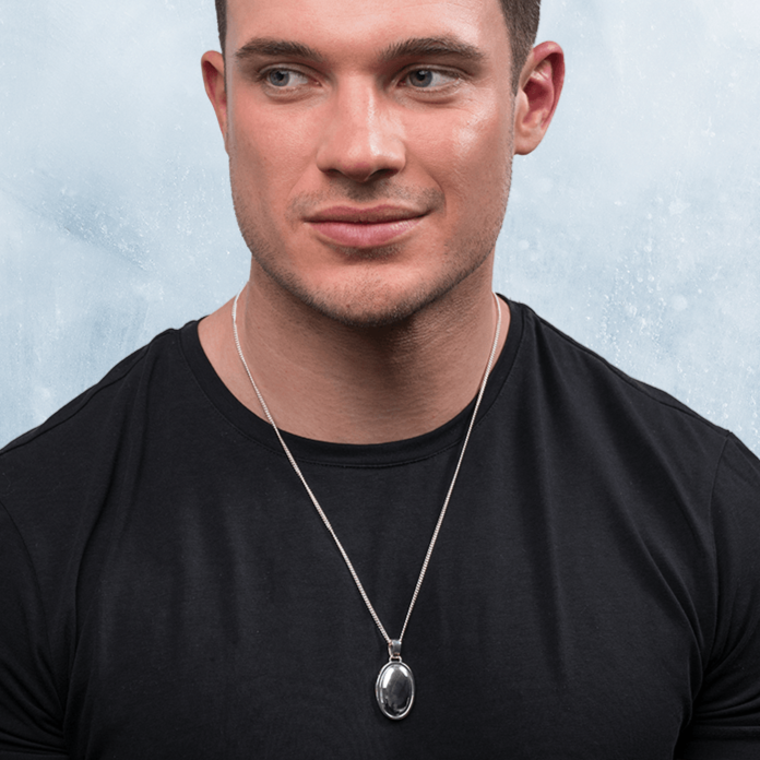 Model wearing a 925 sterling silver mens' oval locket o a sterlinf silver curb chain