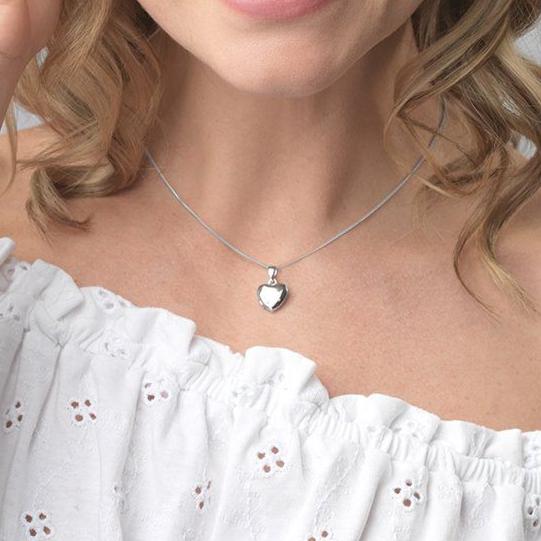 Model wearing a petite 9 ct white gold heart locket on a 9 ct white gold curb chain