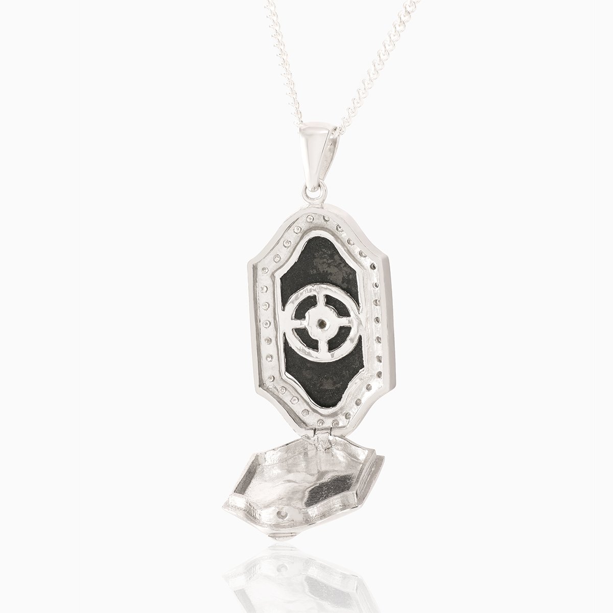 Open view of a 9 ct white gold plaque locket set with an onyx plaque surrounded by diamonds and a seed pearl in the middle surrounded by diamonds. On a 9 ct white gold curb chain