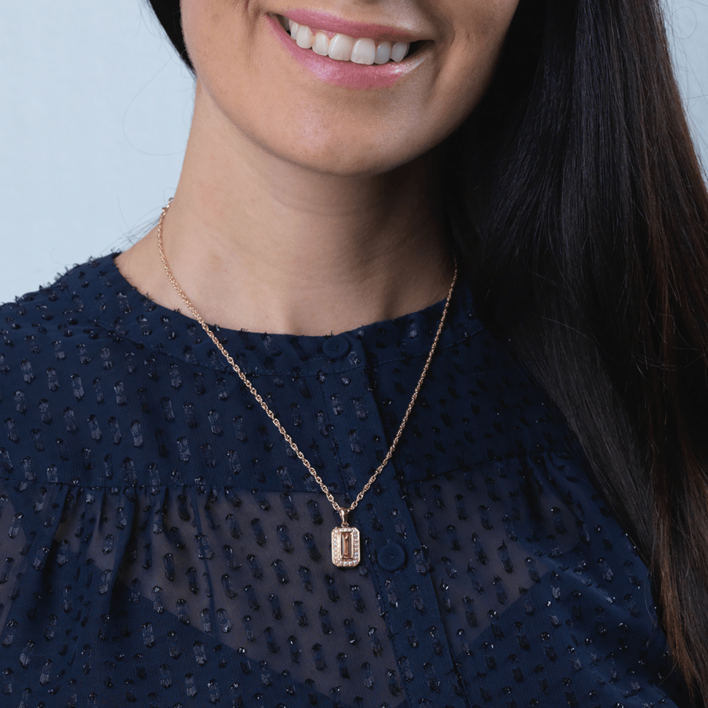 Model wearing a 9 ct gold tabular shaped locket set with a citrine and seed pearls ona 9 ct gold rope chain