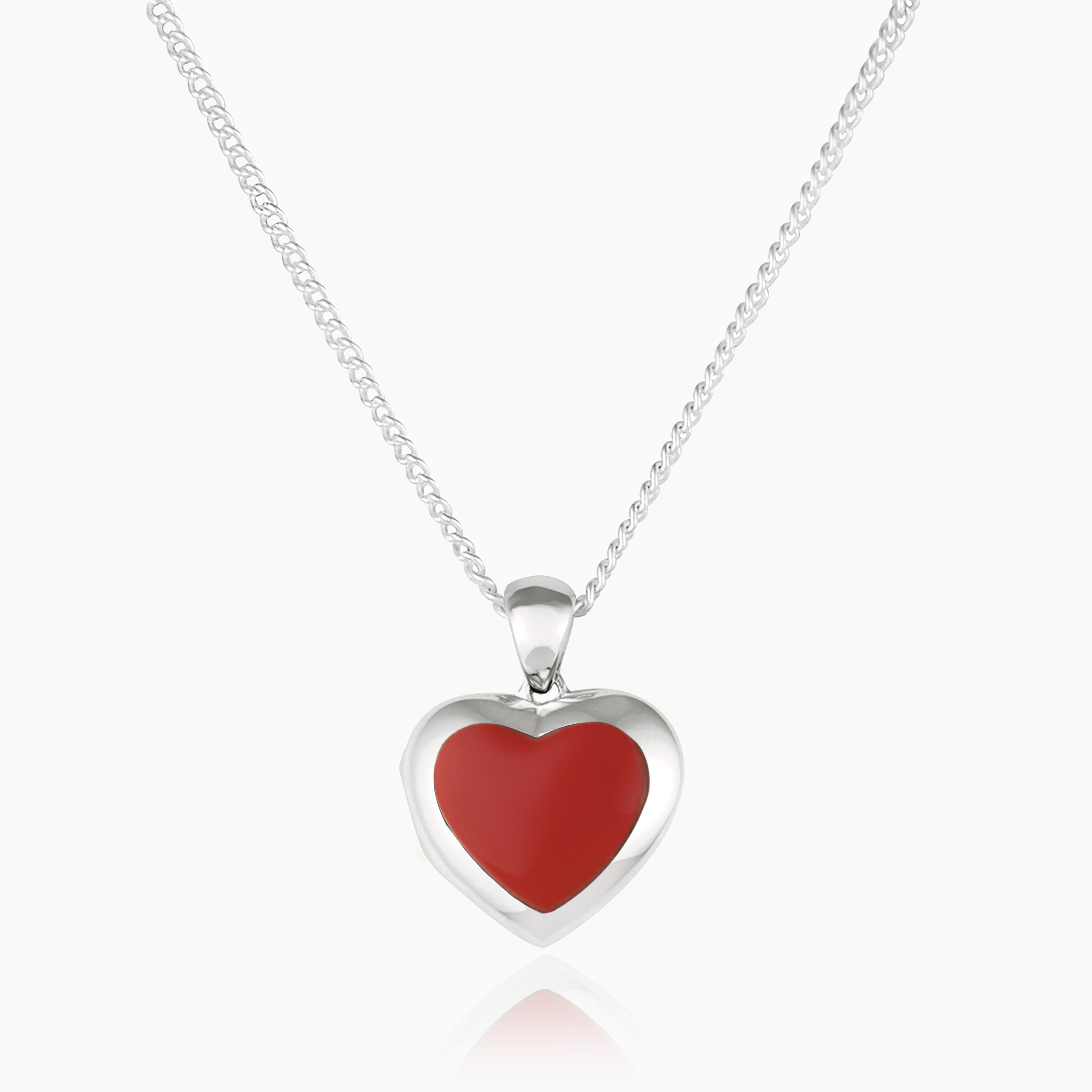 Front shot of a petite heart-shaped sterling silver locket set with red coral on a sterling silver curb chain.