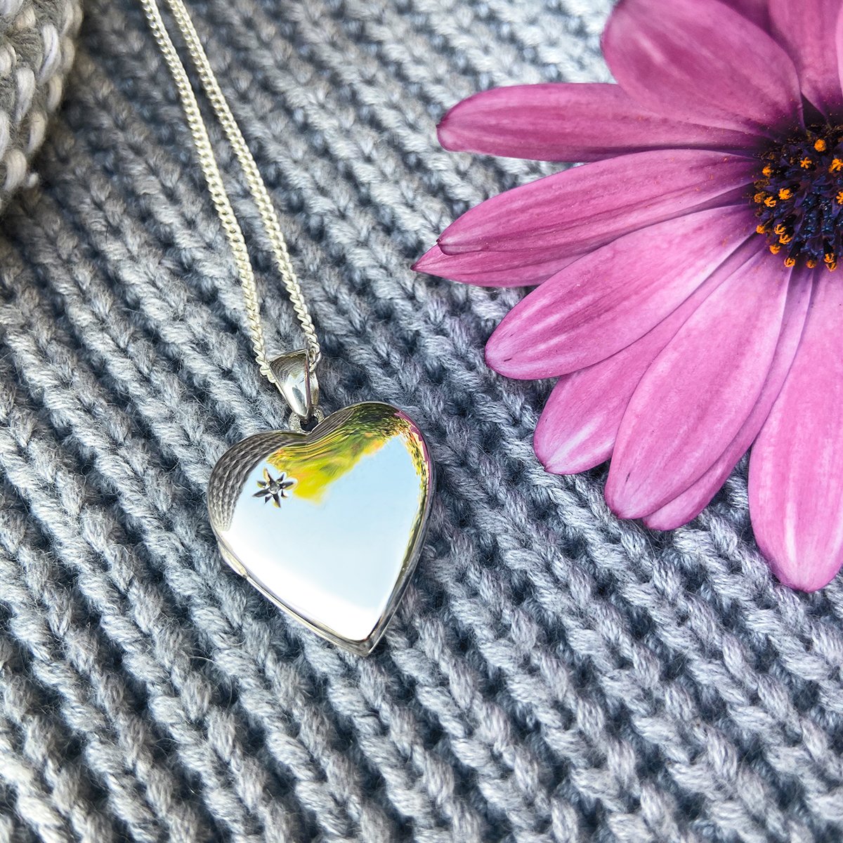 sterling silver heart locket set with a diamond in the top left corner, on a sterling silver curb chain