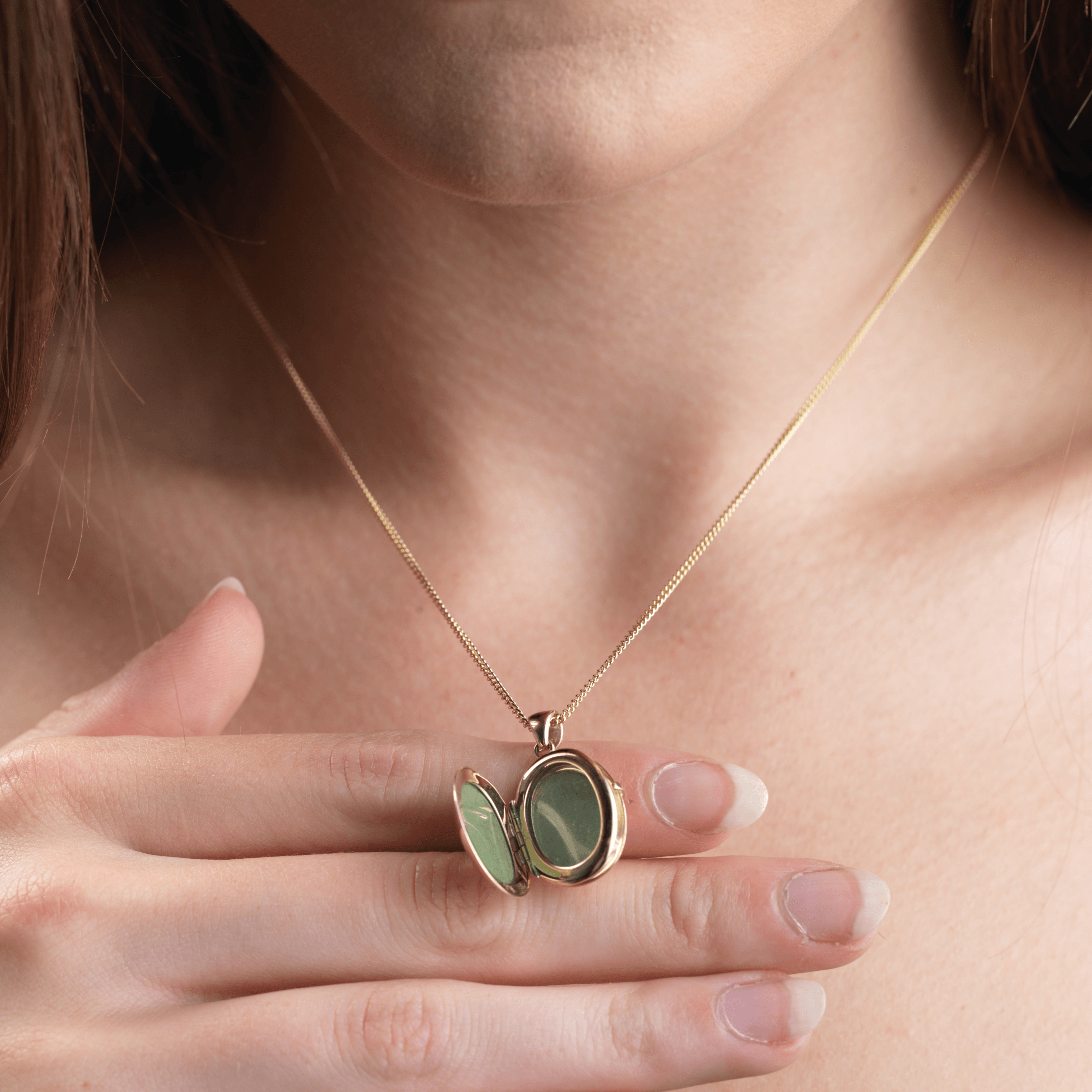 Model holding an open 9 ct gold oval 4-photo locket on a 9 ct gold curb chain