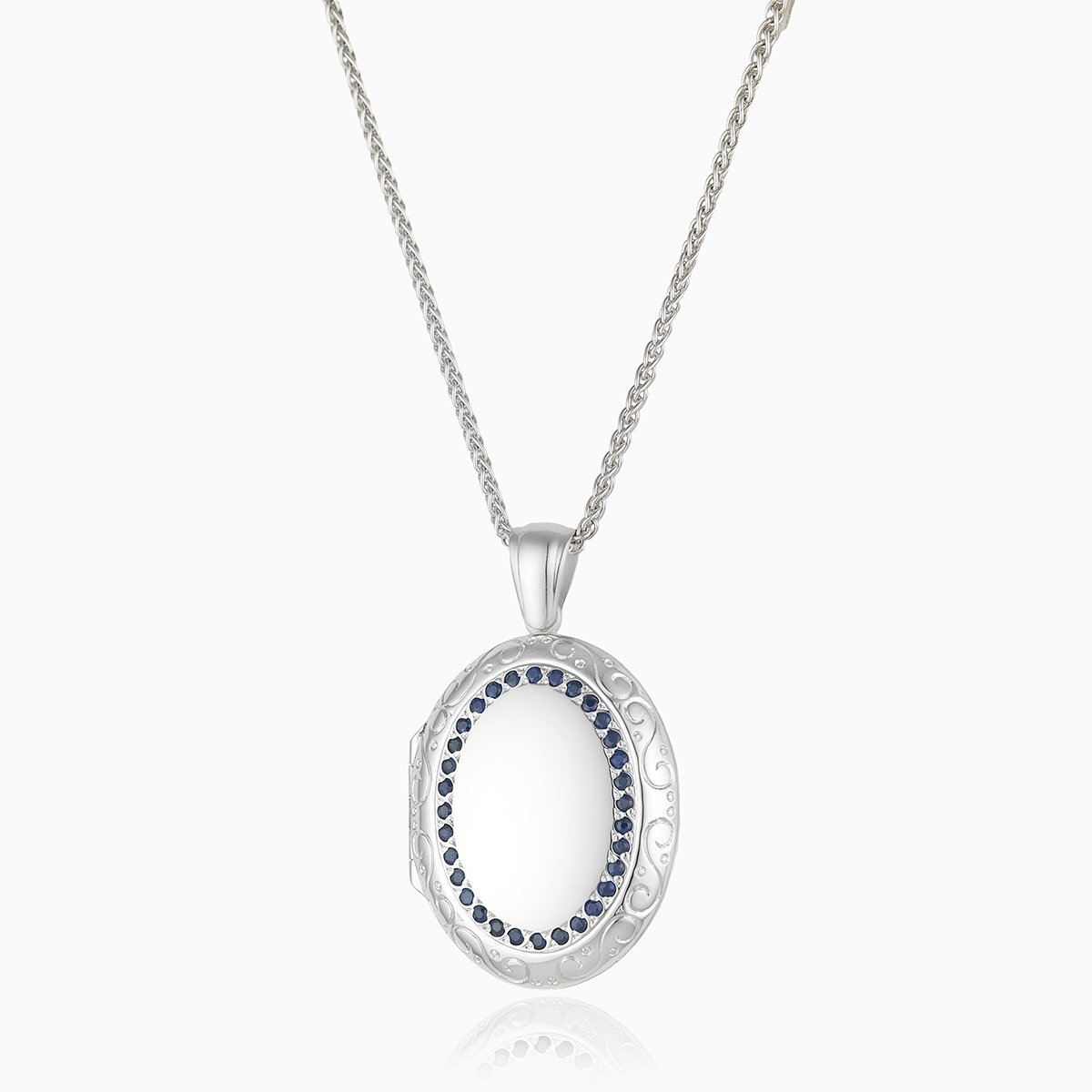 18 ct white gold large oval 4-photo locket set with blue sapphires and an engraved border, on an 18 ct white gold spiga chain