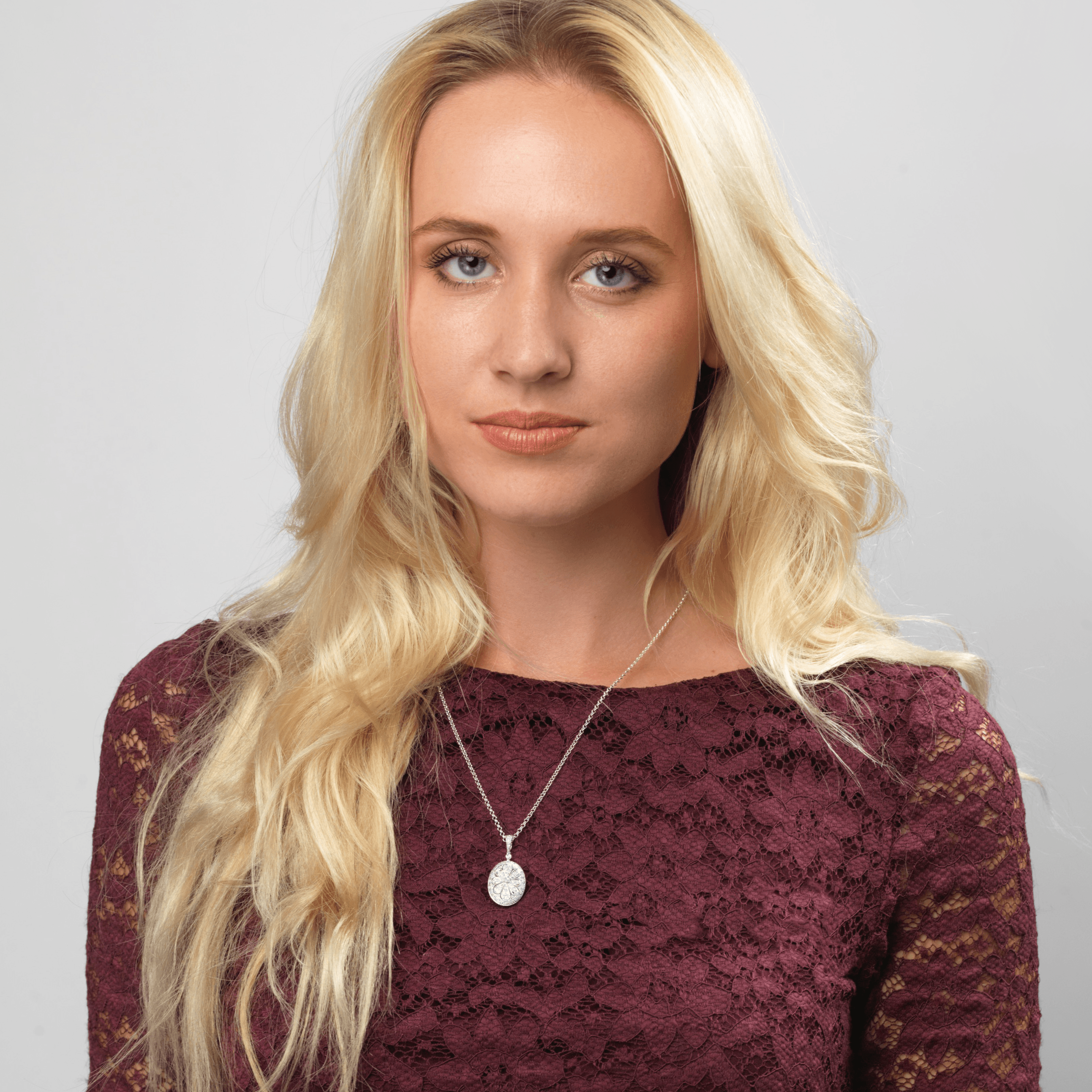 Model wearing a 9 ct white gold oval locket pave set with diamonds in a floral design on a 9 ct white gold curb chain