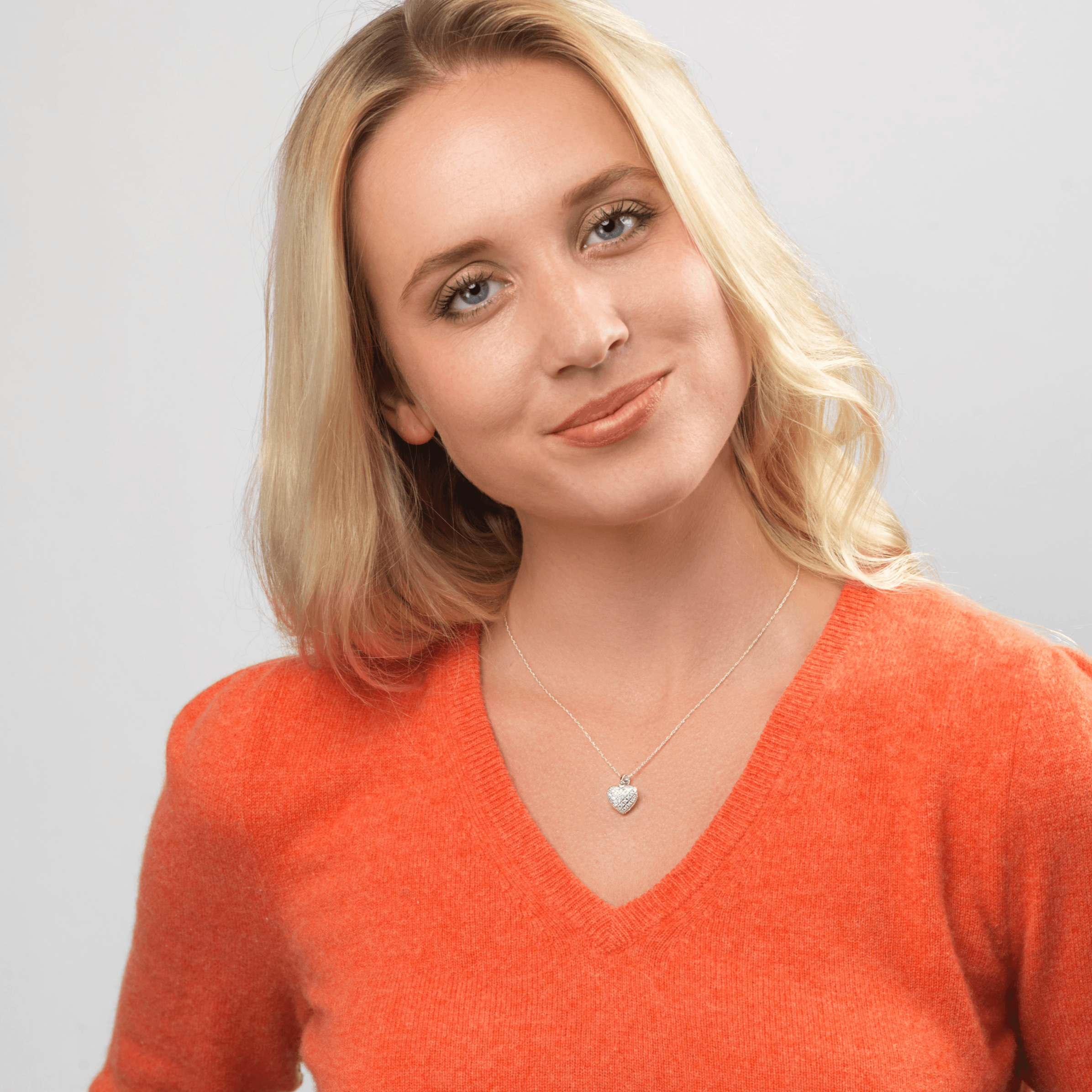 Model wearing a petite 9 ct white gold heart locket pave set with diamonds on a 9 ct white gold curb chain.