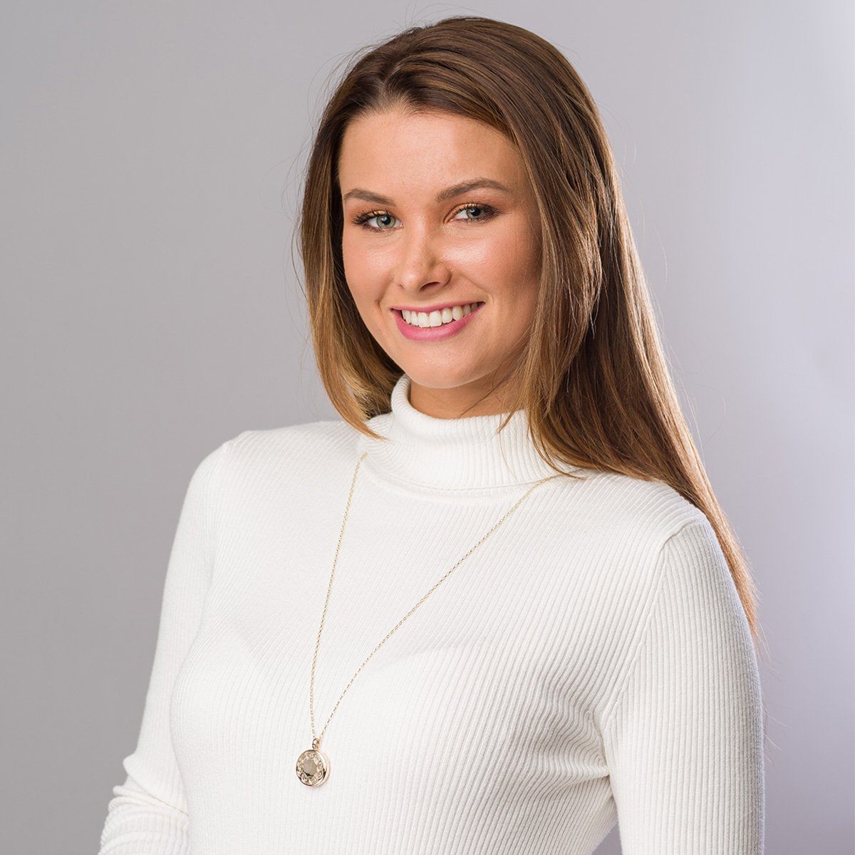 Model wearing a 9 ct gold round locket with an engraved Celtic design border on a 9 ct gold chain