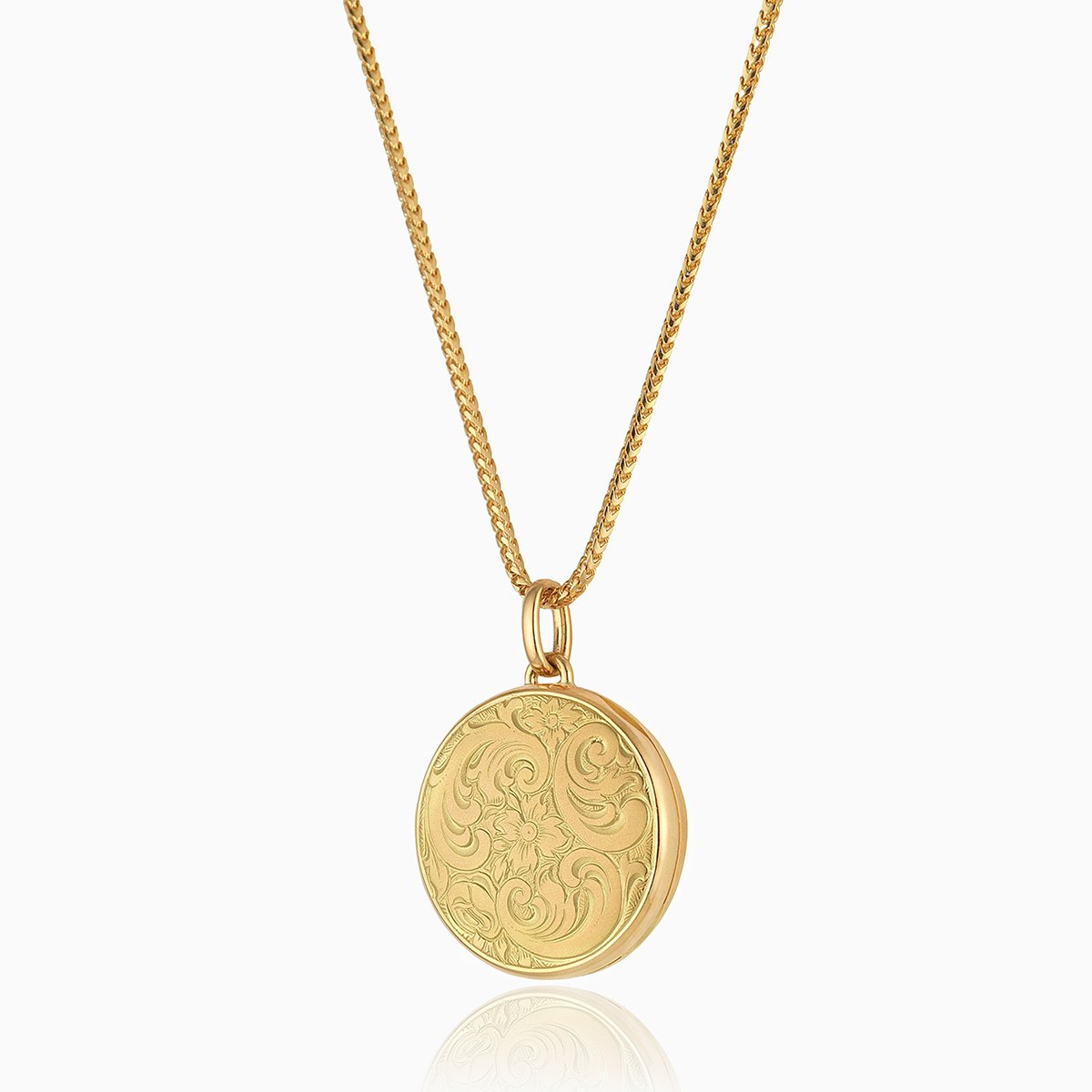 18 ct gold round locket engraved with a floral design on an 18 ct gold franco design