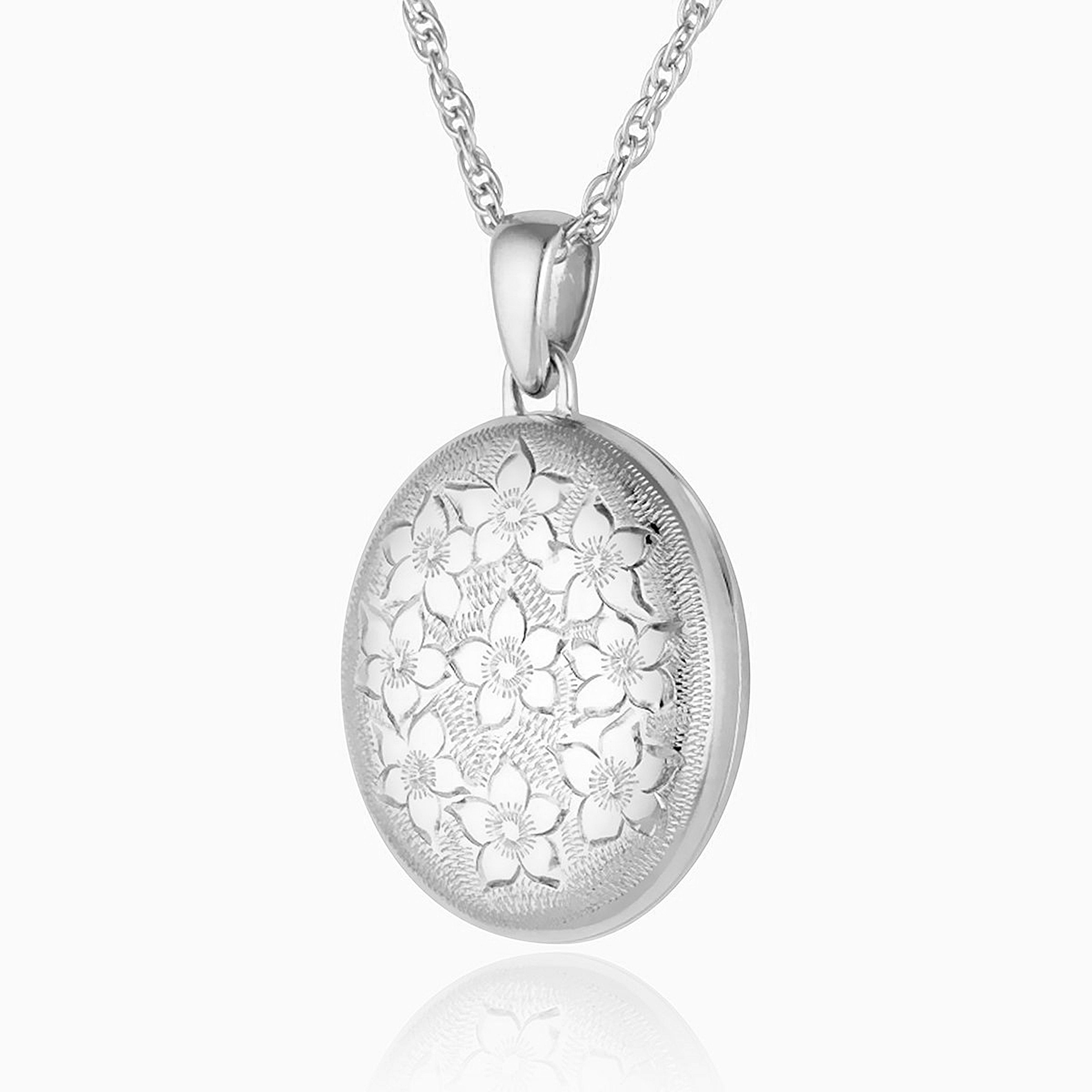 sterling silver oval locket engraved all over with a floral design, hanging on a sterling silver rope chain