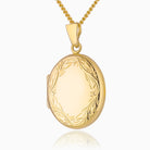 Oval Gold locket with a curb chain that has engraved boarder. 