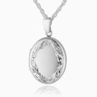 Close-up photo of a 925 sterling silver locket with a hand-engraved traditional foliate border placed on a curb chain.