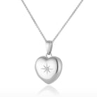 Photo of a premium petite white gold heart locket with a star set diamond in the middle and placed on a curb chain.