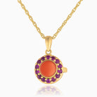 Photo of a petite round 9 ct gold locket with a red coral in the middle and matching rubies surrounding it placed on a 9 ct gold base with a 9ct gold chain accompanying it.