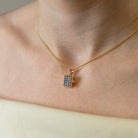 Model wearing a 9ct gold rectangular locket studded with real sapphires placed on a 9ct gold rope chain.