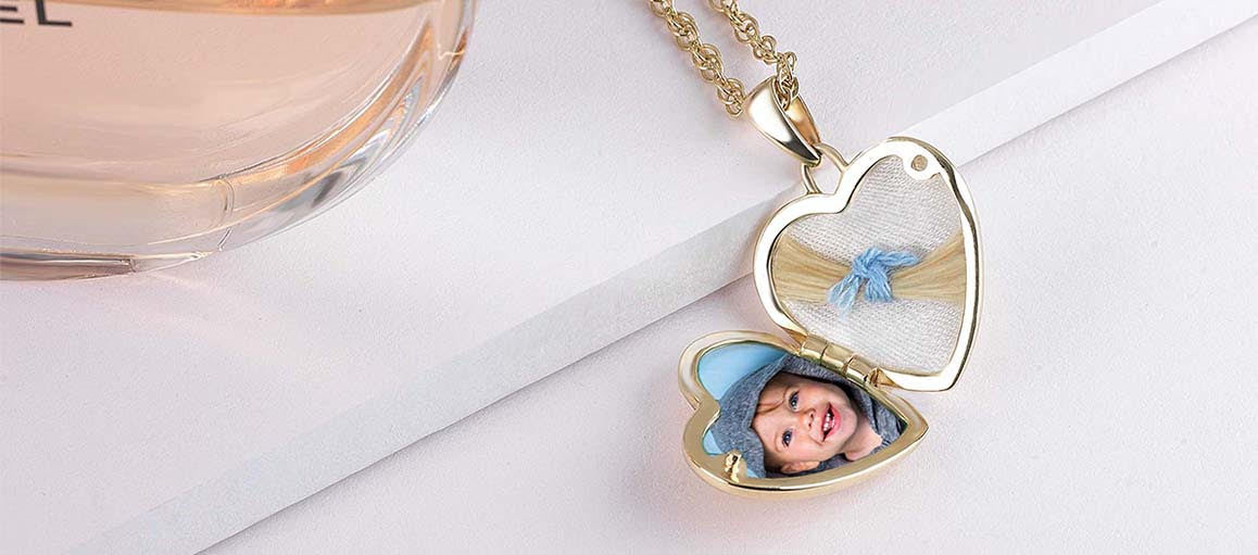 An open gold heart locket holding a lock of hair and a baby photograph