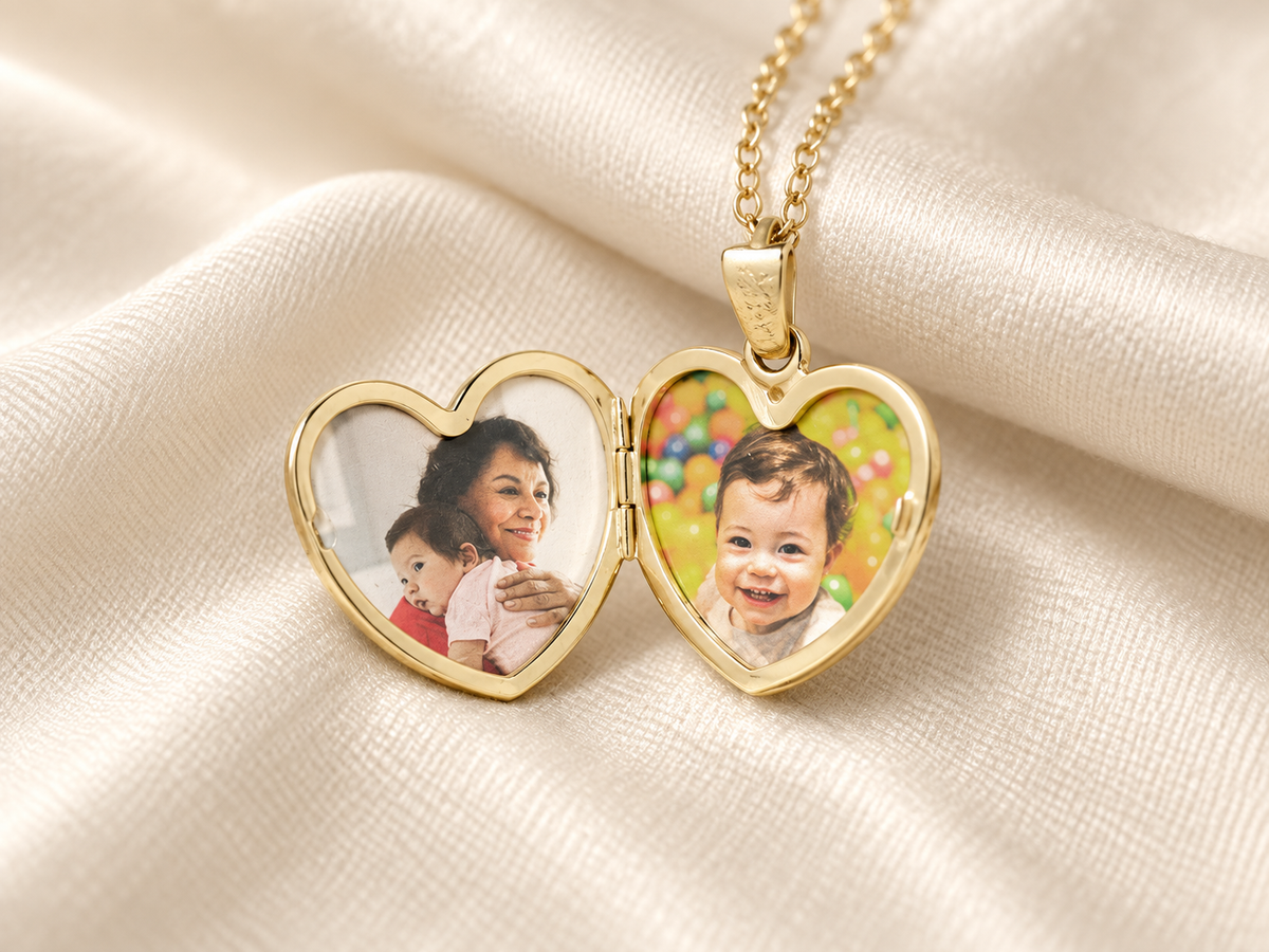 An open gold heart locket holding two family photographs on cream fabric