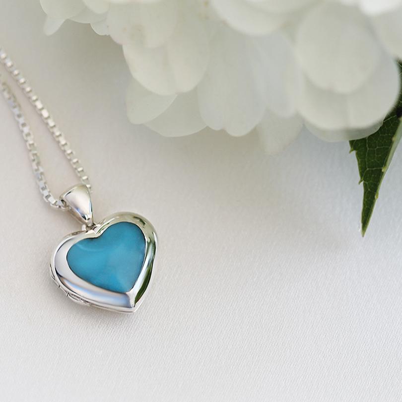 Front shot of a petite heart-shaped sterling silver locket set with reconstituted turquoise on a sterling silver box chain.