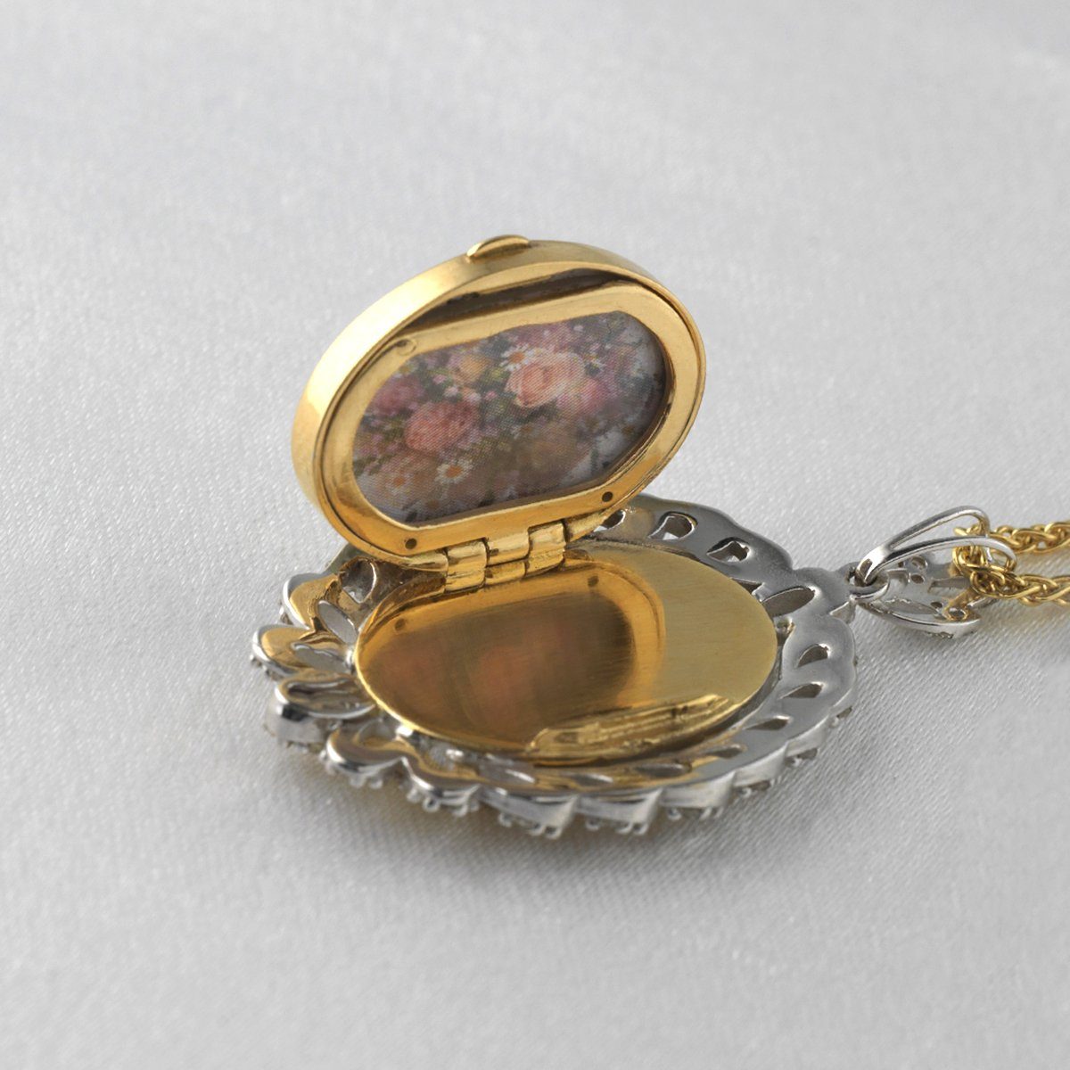 Open view of an 18 ct gold oval locket set with an 18 ct white gold rope twist border