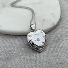 18 ct white gold heart locket set with 9 star set diamonds on an 18 ct white gold franco chain
