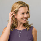 model wearing a sterling silver oval locket with filigree front and a central purple amethyst, on a sterling silver rope chain