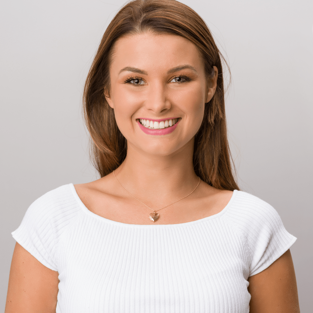 Model wearing a 9 ct gold heart locket with a satiin and polished design on the front on a 9 ct gold chain