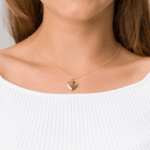 Model wearing a 9 ct gold heart locket with a satiin and polished design on the front on a 9 ct gold chain