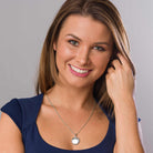 model wearing a 925 sterling silver round locket with engraved foliate border