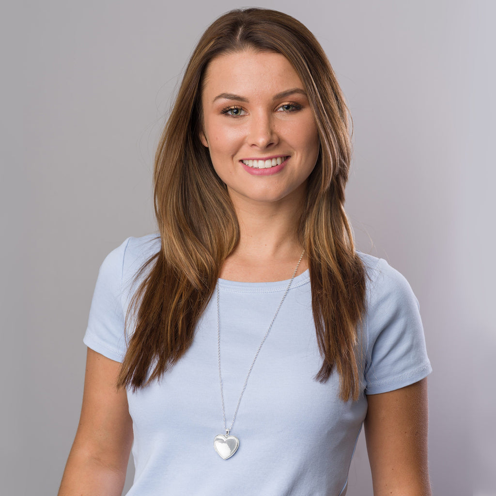 Model in blue shirt wearing a large sterling silver rope twist border locket. 