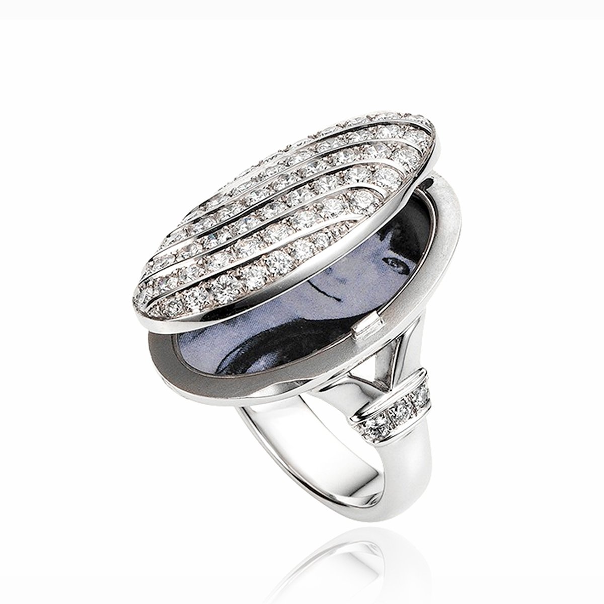 An ope view of an 18 ct white gold oval locket ring pave set with diamonds. There are also diamonds set across the shank.