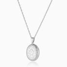 sterling silver oval locket engraved all over with a floral design, hanging on a sterling silver rope chain