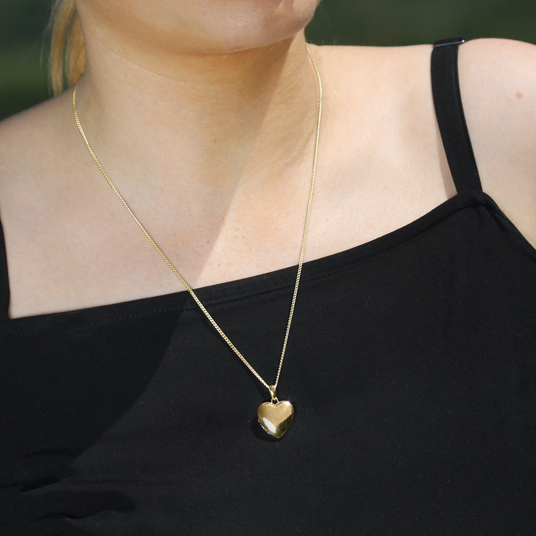 model wearing a 9 ct gold heart locket on a 9 ct gold curb chain