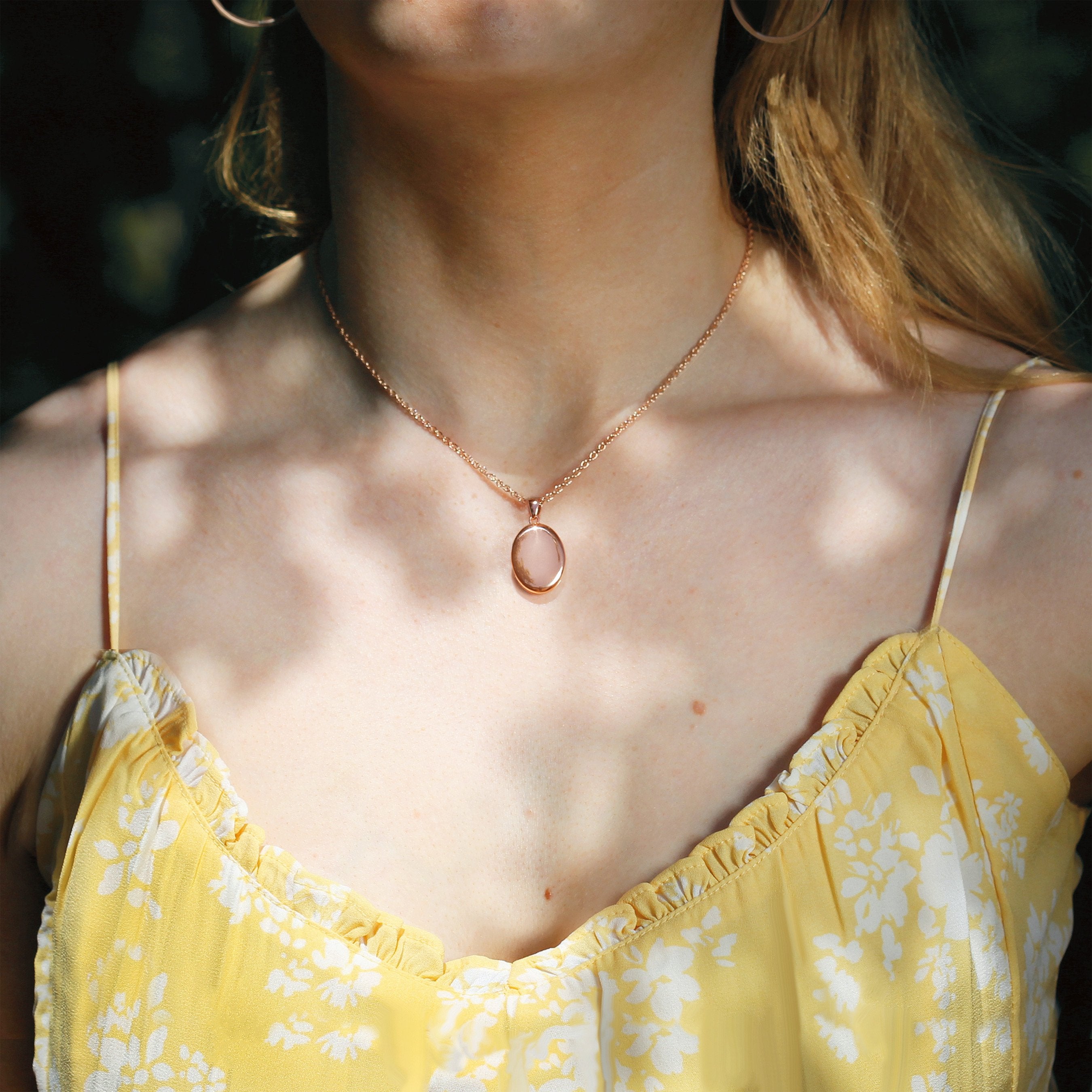 Model wearing a 9 ct rose gold oval locket with a 9 ct rose gold curb chain.