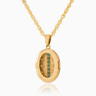 Back view of a petite 9 ct gold oval locket set with emeralds and seed pearls on a 9 ct gold rope chain.