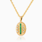 Petite 9 ct gold oval locket set with emeralds and seed pearls on a 9 ct gold rope chain.