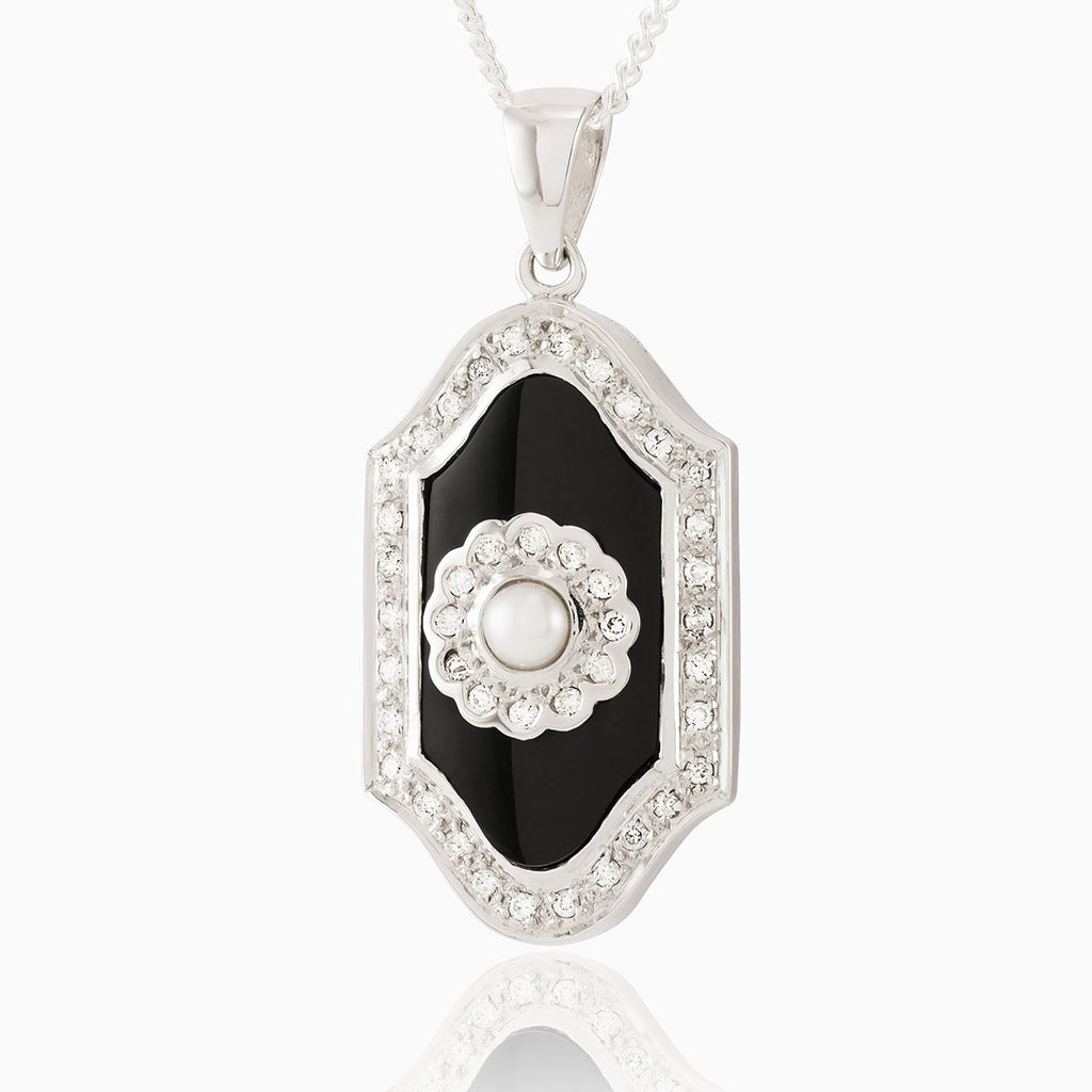 9 ct white gold plaque locket set with an onyx plaque surrounded by diamonds and a seed pearl in the middle surrounded by diamonds. On a 9 ct white gold curb chain