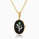 9 ct gold oval locket set with diamonds and a white gold floral design on an onyx background, on a 9 ct gold rope chain