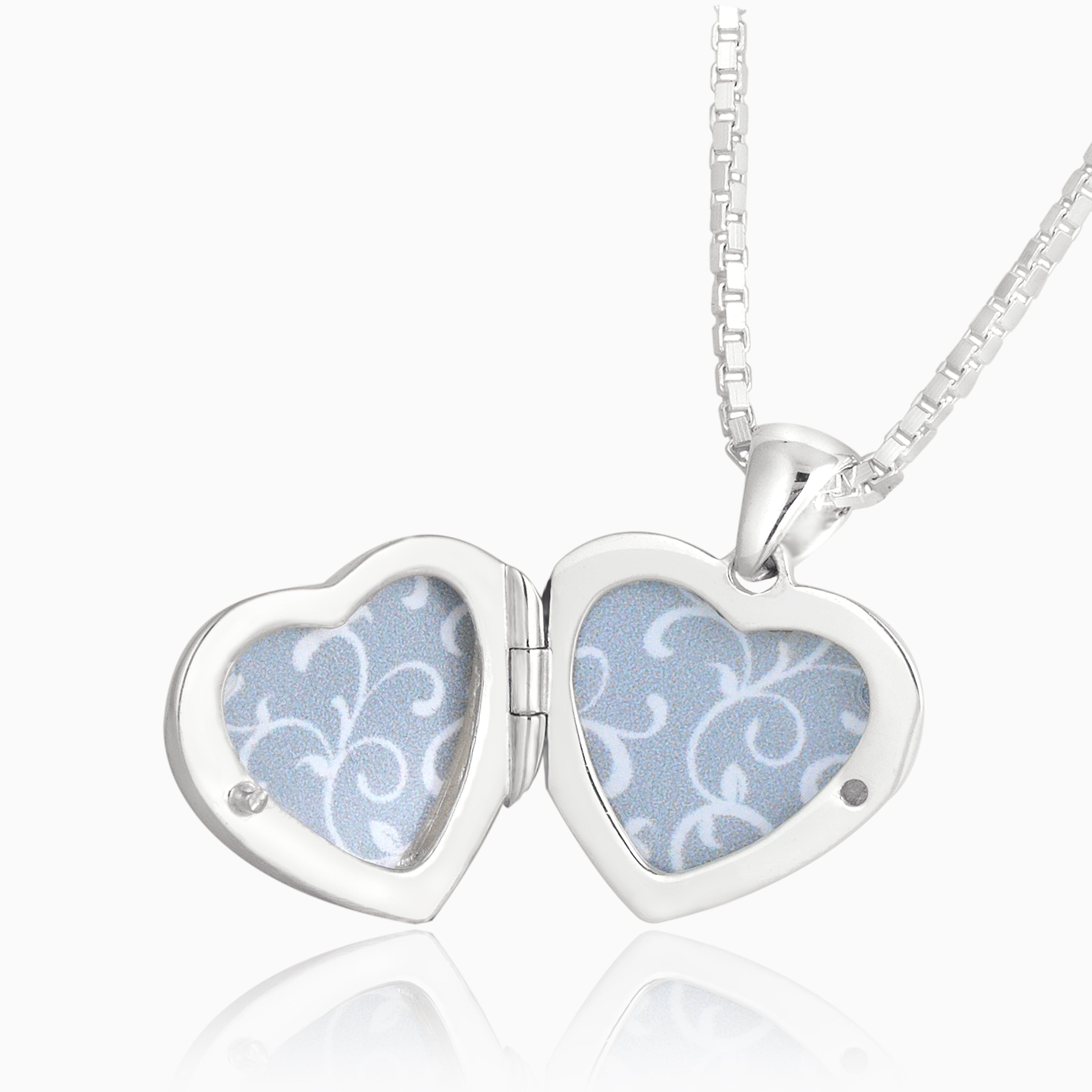 Open shot of a petite heart-shaped sterling silver locket set with red coral on a sterling silver box chain.