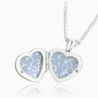 Open shot of a petite heart-shaped sterling silver locket set with lapis lazuli on a sterling silver box chain.