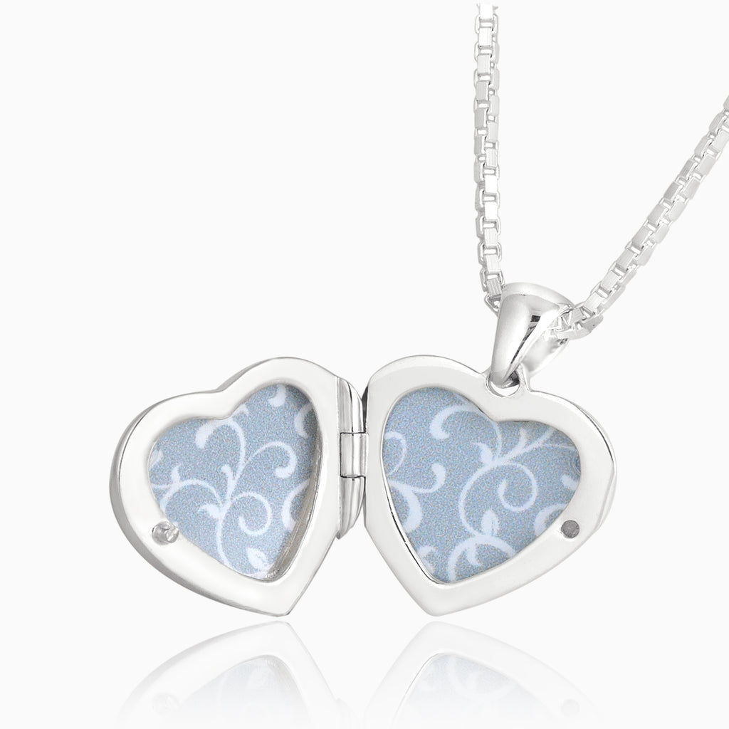 Open shot of a petite heart-shaped sterling silver locket set with abalone shell on a sterling silver box chain.