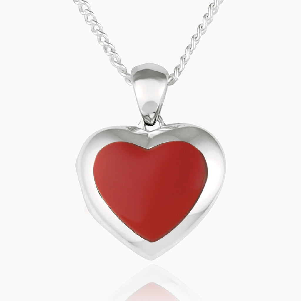 Front shot of a petite heart-shaped sterling silver locket set with red coral on a sterling silver curb chain.