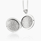 open view of a sterling silver round locket with grey paper inserts and perspexes