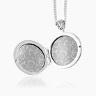 open view of a sterling silver round locket with grey linings and paper inserts